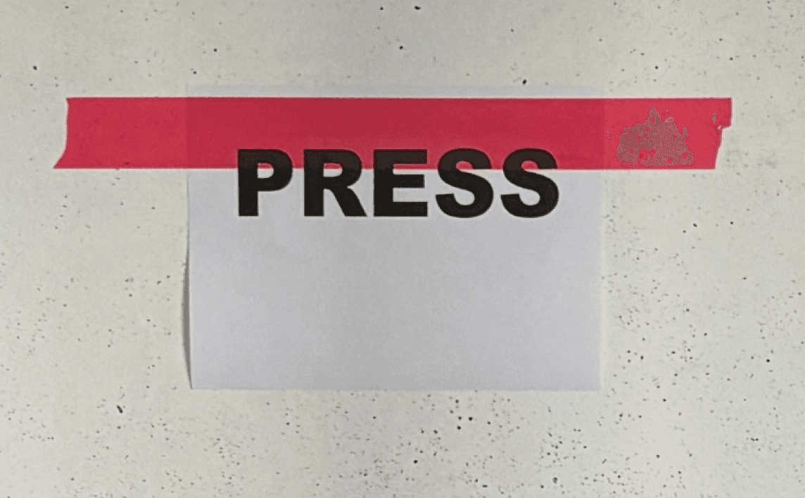 PRESS poster taped to a wall